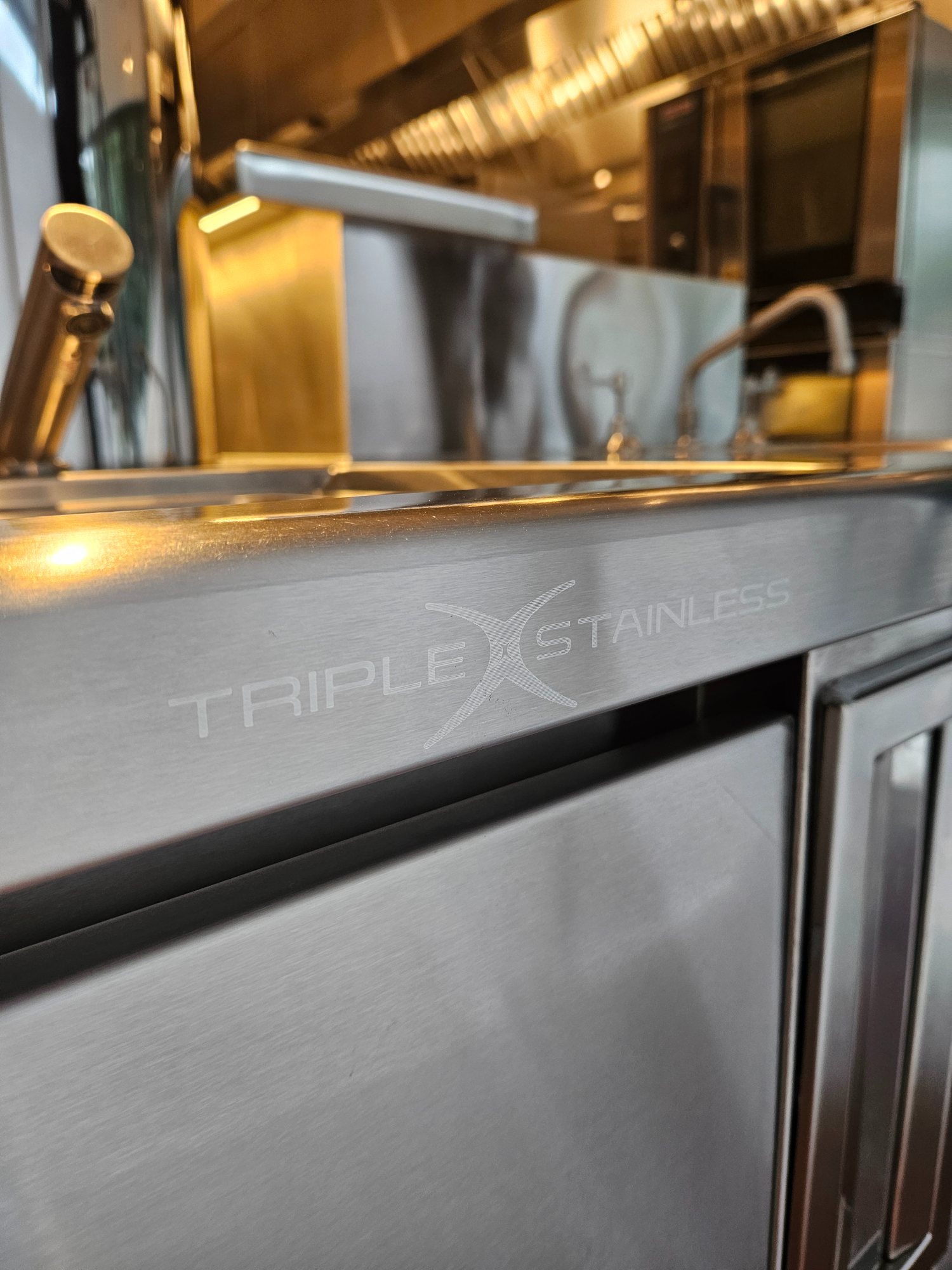 Triple X Stainless logo laser-etched into a fabricated bench